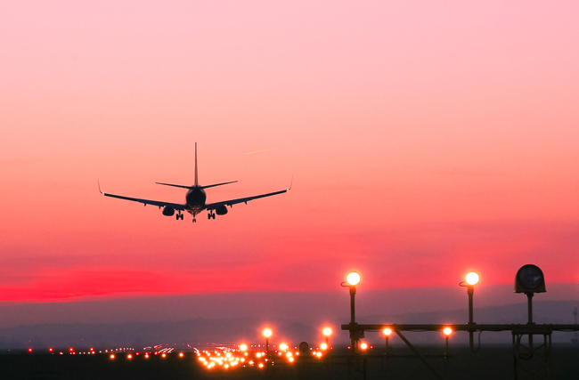 Ankunft eines Flugzeuges am Flughafen währen eines roten Sonnenuntergangs