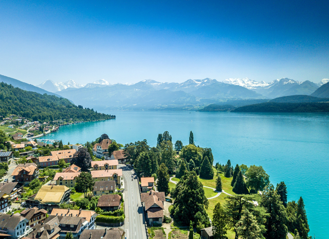 Vue aérienne d'un village suisse avec un lac en arrière-plan