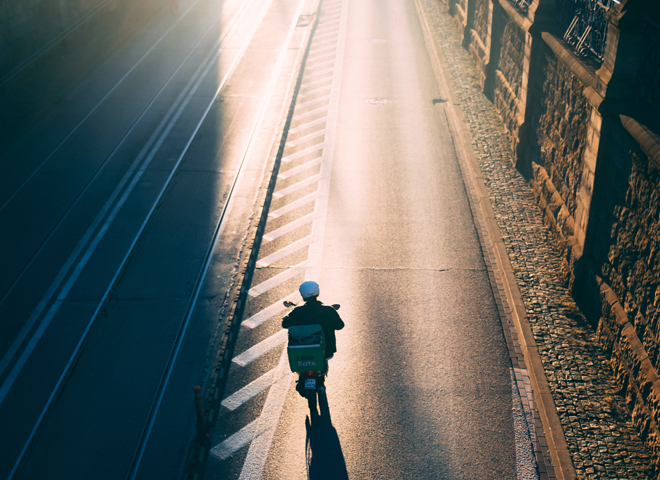 Un homme roule sur un scooter vers le soleil