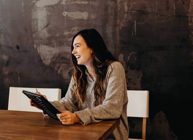 Travail temporaire, emploi fixe, flexibilité: une jeune femme avec une tablette sourit