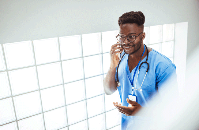 junge Pflegefachkraft in blauem Kittel telefoniert mit einem Recruiter