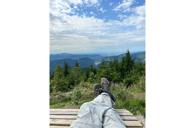 Aussicht auf Berge, Täler und Tannen, im Vordergrund die Füsse in Wanderschuhen von Autor Thorsten Eger, symbolisch für die Erfolge der OKR-Methode