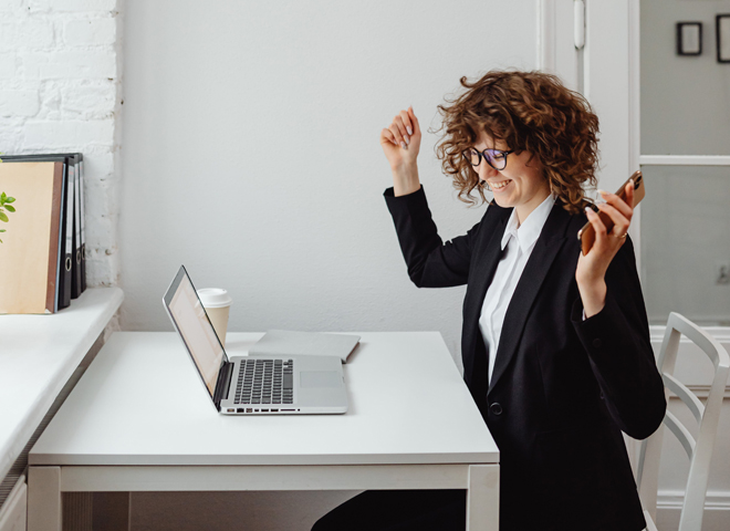 (Re)trouver le plaisir de travailler: une femme contente assisse à son bureau