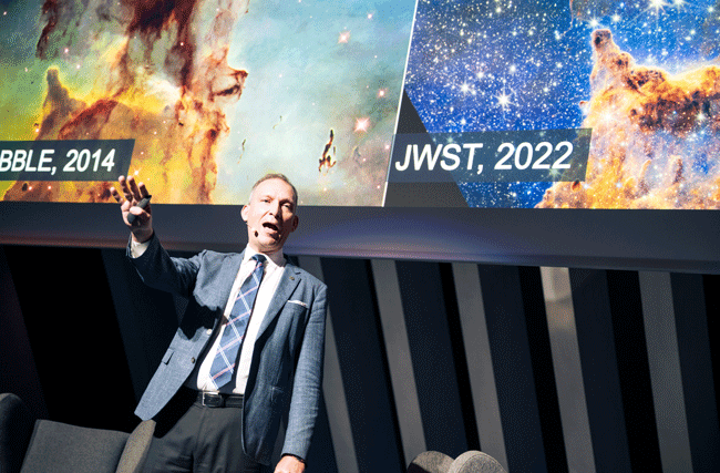 Astrophysiker der NASA und ETH Professor Thomas Zurbuchen hält eine Keynote vor einem Hintergrund mit Bildern der Milchstrasse.