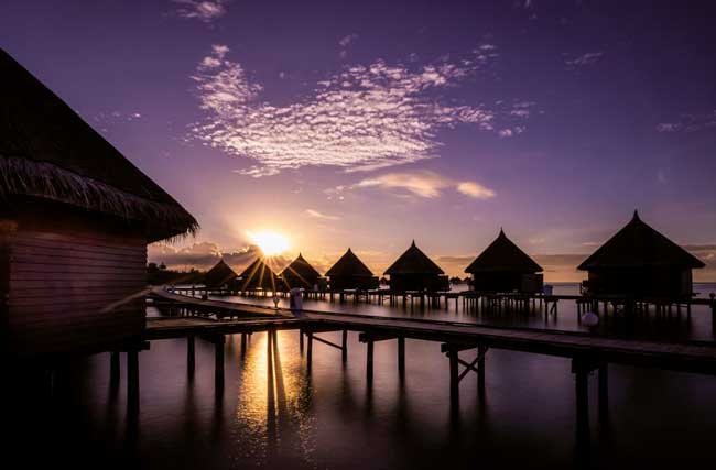 Idyllische Hütten vor Sonnenuntergang am Meer in den Malediven