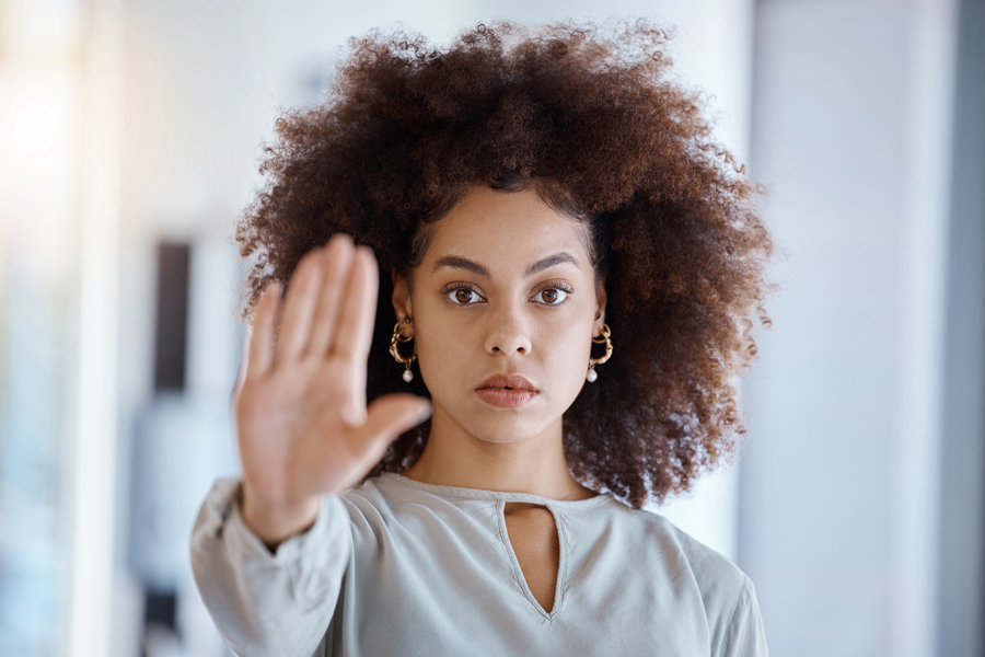 Une femme lève sa main pour dire stop