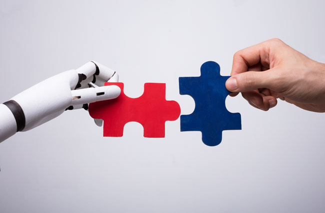 Roboter und Mensch setzen ein Puzzle zusammen, symbolisch für die Zusammenarbeit von KI und Mensch