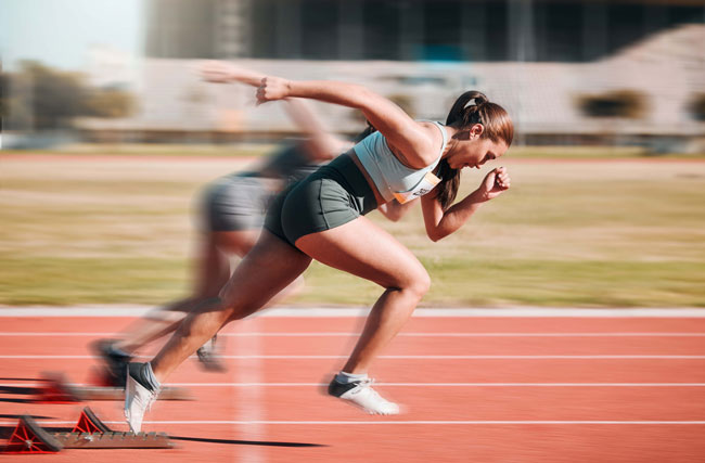 Eine Athletikerin sprintet los, symbolisch für Antrieb und Motivation