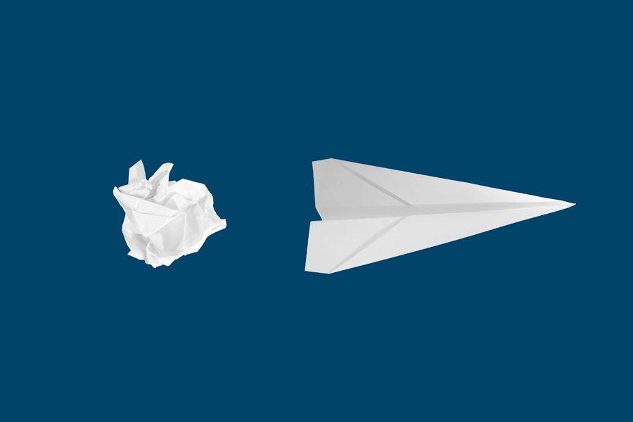 Une boule de papier et un avion de papier sur un fond bleu
