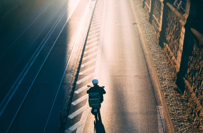 Un homme roule sur un scooter vers le soleil