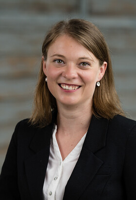 Das Bild zeigt Franziska Bärtsch, eine Frau, lachend, mit längeren Haaren, Blazer und Bluse/Hemd.