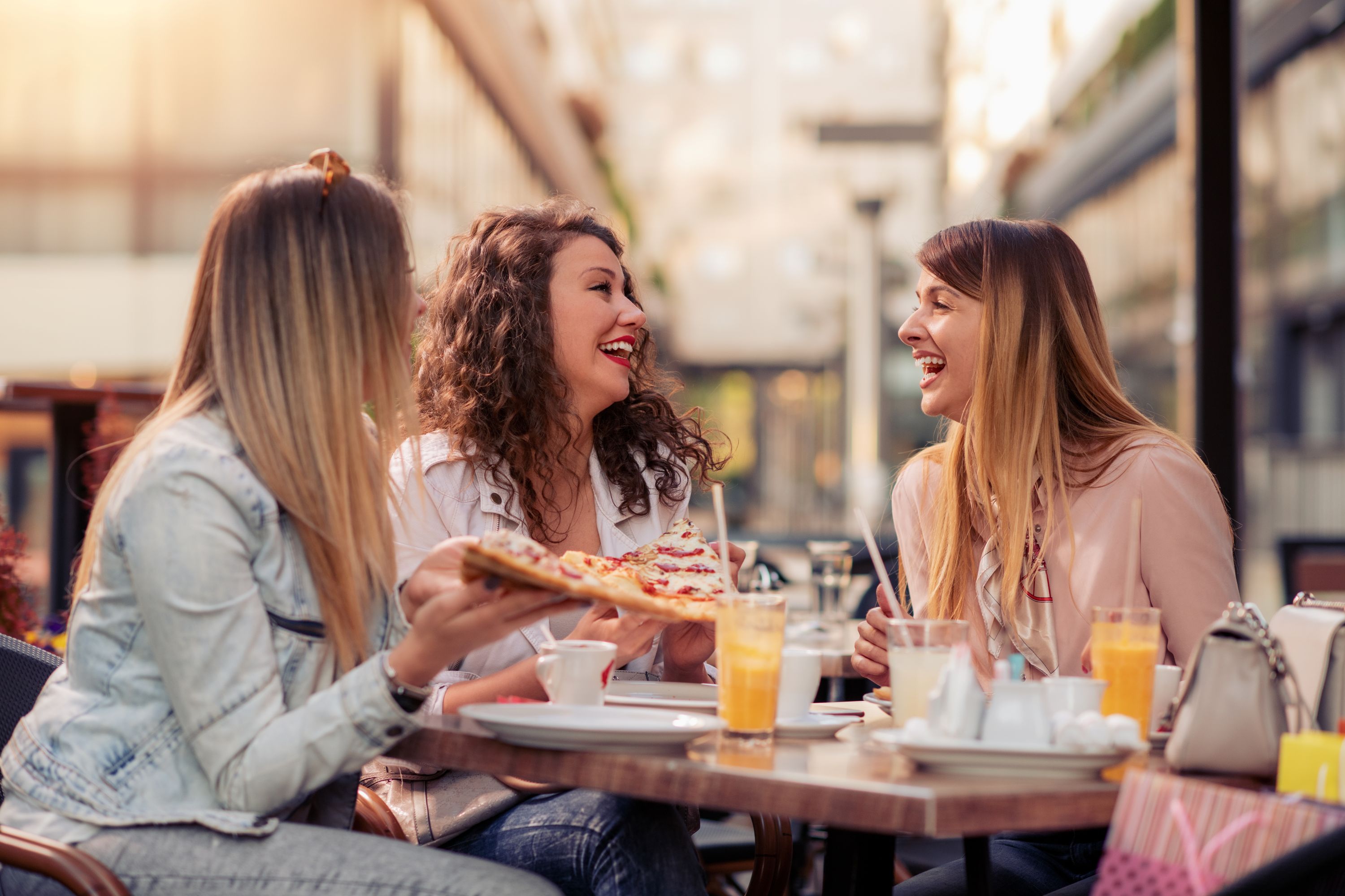 Eine Gruppe glücklicher Frauen rund um einen Tisch beim Essen – Bildsprache: Stock Photo.