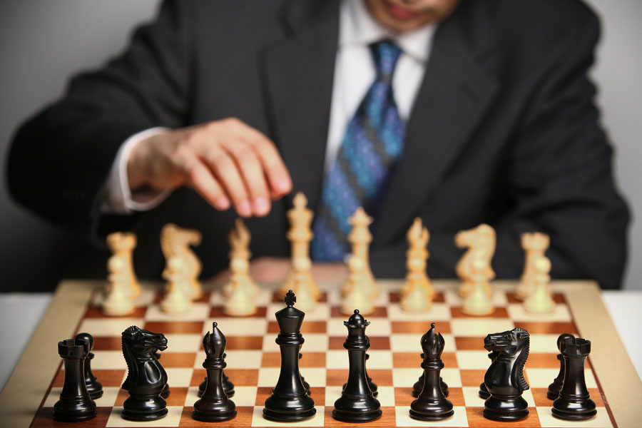 Un homme en costume joue aux échecs