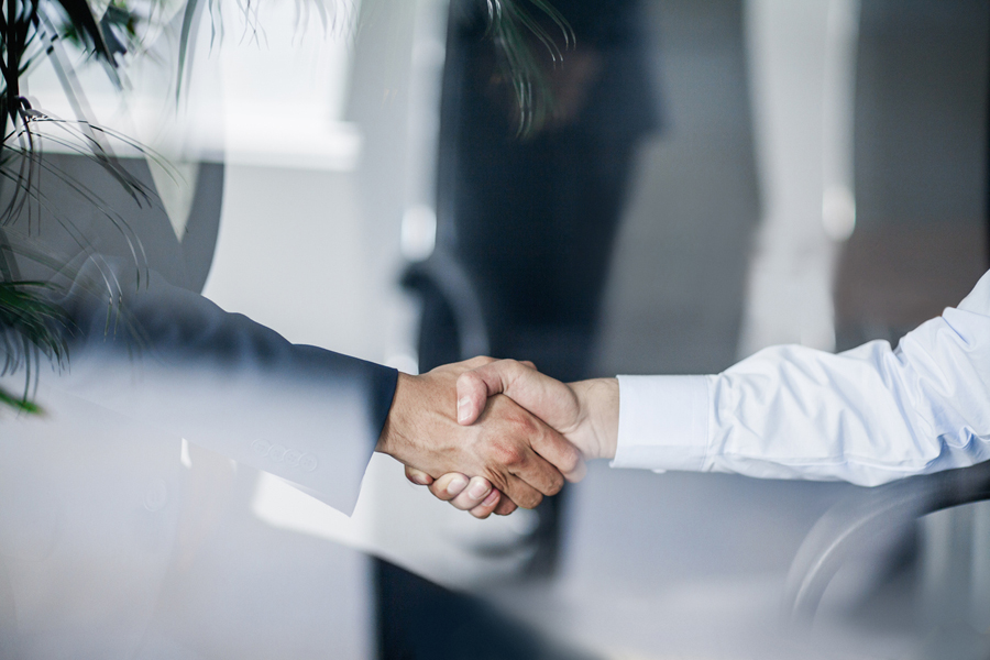 Deux hommes se serrent la main dans un bureau