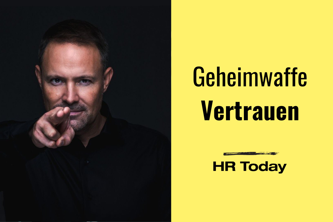 Leo Martin blickt mit einem intensiven, fokussierten Ausdruck direkt in die Kamera und deutet mit seiner Hand eine Pistolen-Geste in Richtung der Betrachtenden an. Er trägt ein schwarzes Hemd vor einem dunklen Hintergrund. Links im Bild stehen auf zwei gelben Textbalken die Worte „Geheimwaffe Vertrauen“. Unten rechts befindet sich das Logo von „HR Today“