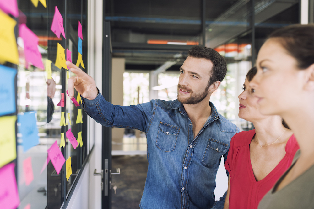 Mitarbeitende an Wand mit Post-its