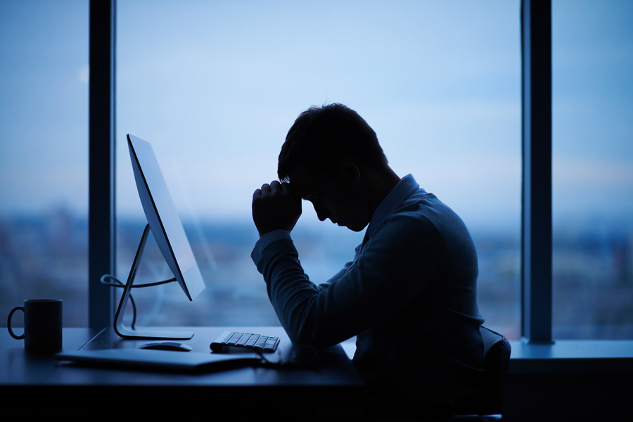 Un homme d'affaires assis devant son ordinateur dans son bureau, le soir