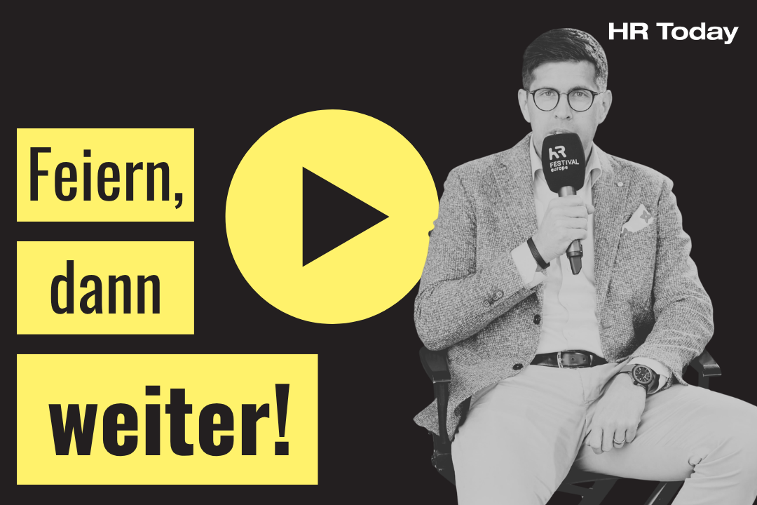 „Feiern, dann weiter!“ auf gelbem Hintergrund. In der Mitte befindet sich ein gelbes Play-Symbol. Rechts sitzt ein Mann im Sakko mit Brille, der ein Mikrofon mit der Aufschrift „HR FESTIVAL europe“ in der Hand hält.