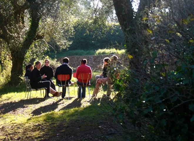 Un groupe d'hommes et de femmes assis sur des chaises dans un champ