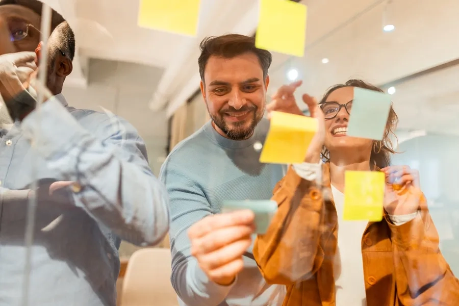 Des collègues participent à une session de brainstorming avec des notes autocollantes.