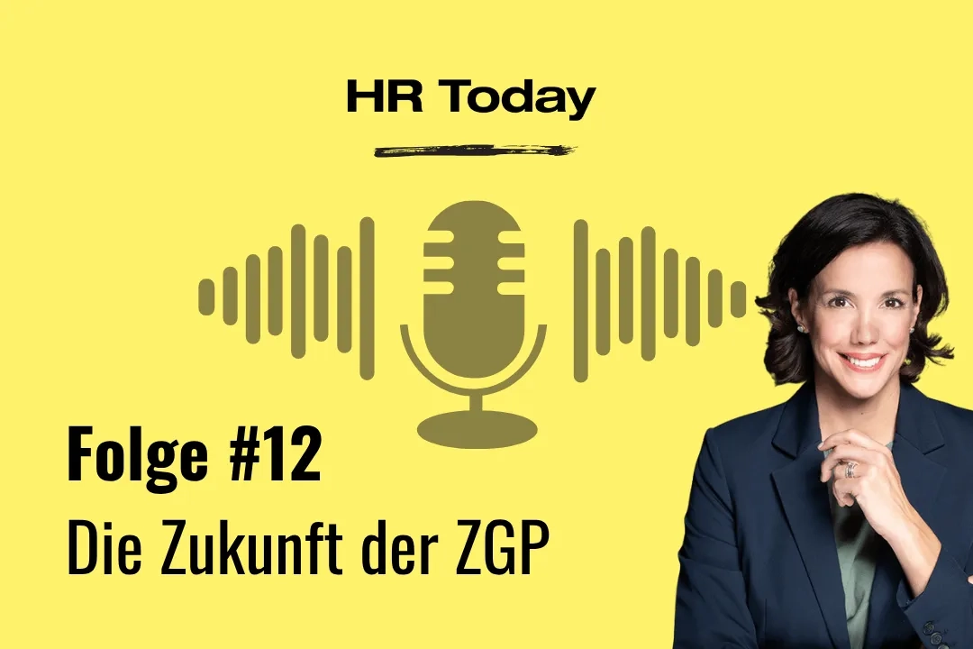 Porträt der Protagonistin im dunkelblauen Blazer vor dunklem Hintergrund – sie blickt direkt in die Kamera und hat eine Hand ans Kinn gelegt.