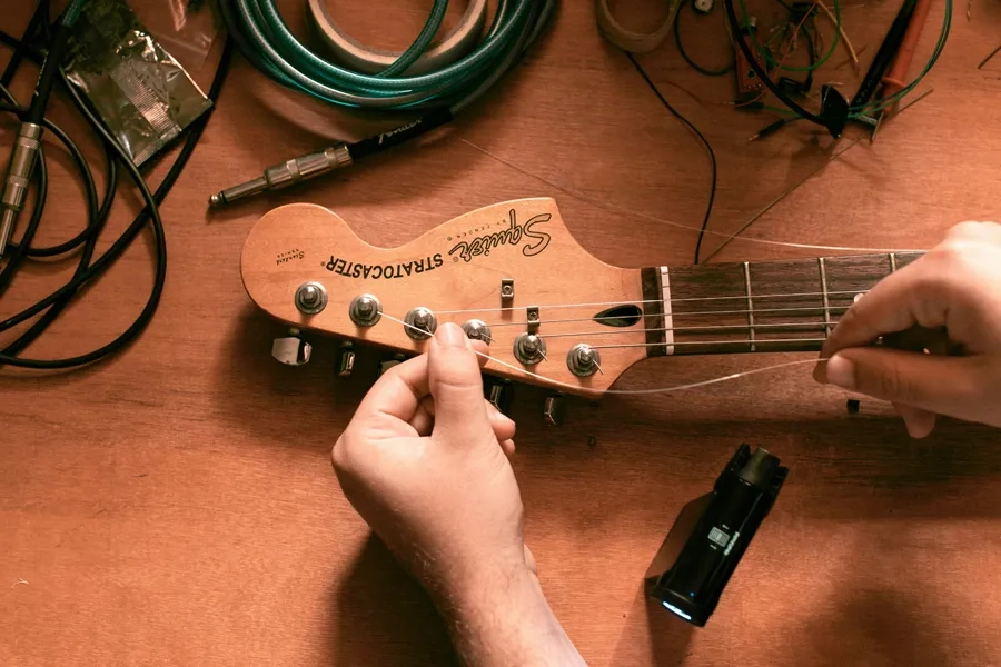 Un homme accorde une guitare