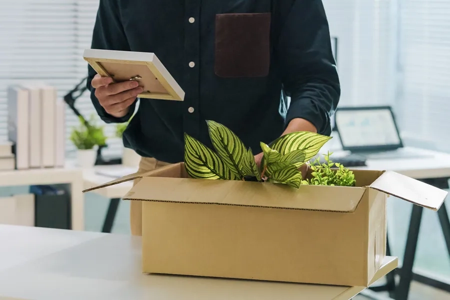 Un homme licencié range ses affaires dans un carton