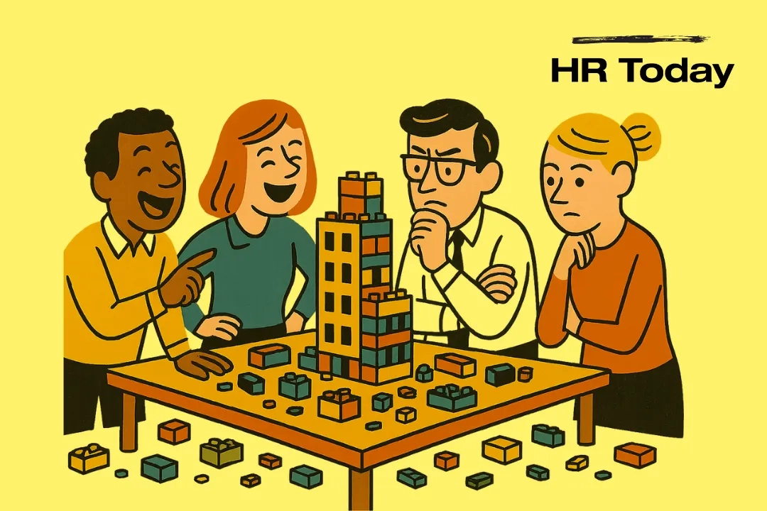 Vier diverse Mitarbeitende stehen um einen Tisch und bauen mit LEGO-ähnlichen Bausteinen einen kleinen Büro-Turm; einige lachen, andere denken konzentriert nach. Auf dem Boden und Tisch liegen verstreut viele Bausteine; flächige, mid-century Illustrationsoptik ohne Text oder Verlauf.