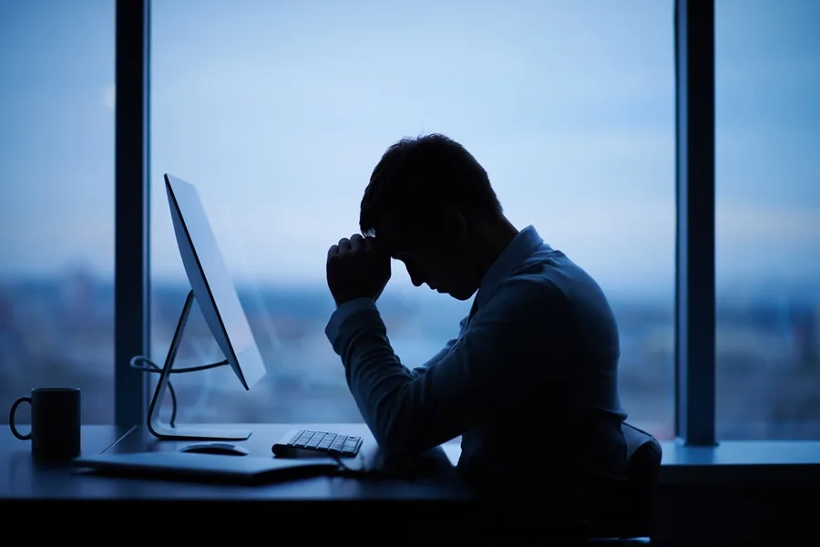 Un homme d'affaires assis devant son ordinateur dans son bureau, le soir