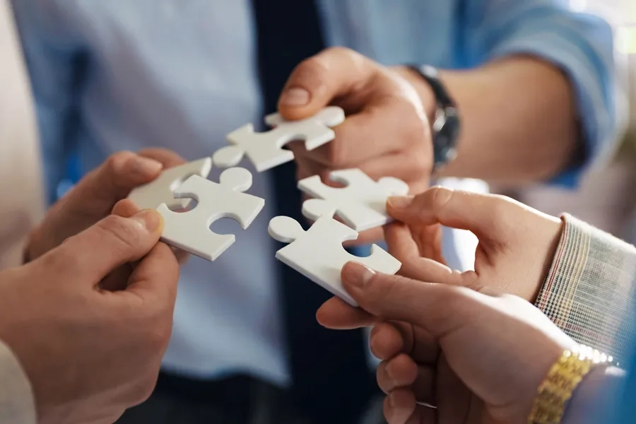 Un groupe de collègues assemble les pièces d'un puzzle